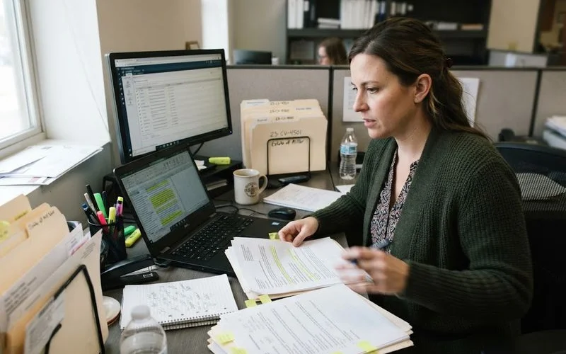 A researcher cross-checking a foreclosure attorney's public business license and recent review sentiment data on two side-by-side screens